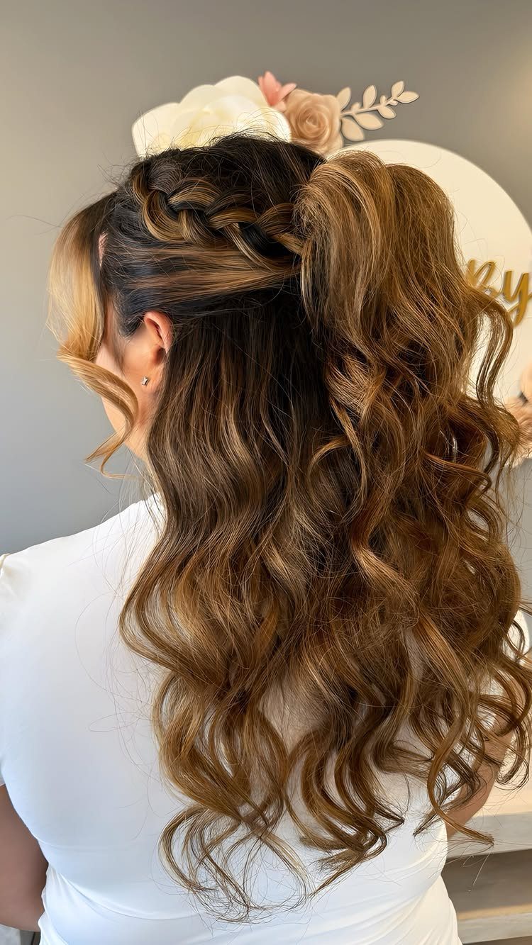 Long curly brown hair styled in a braided half-updo for a formal event.
