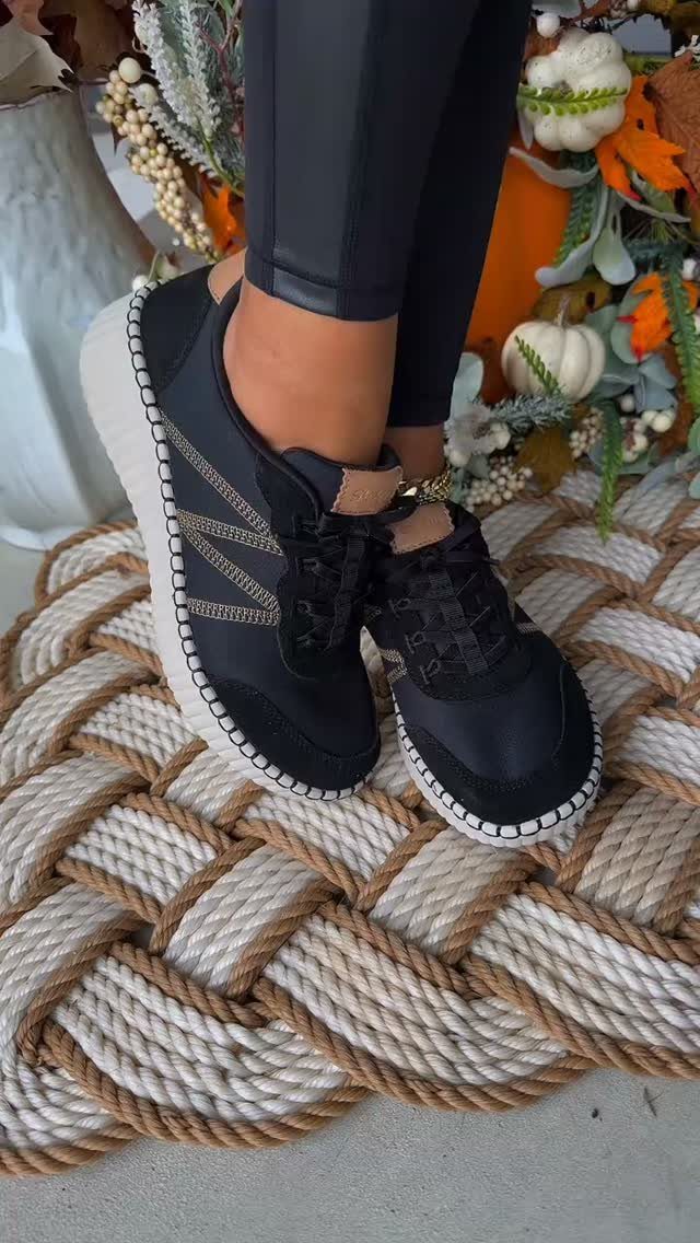 Black wedge sneakers with white soles worn with black leggings on rope mat