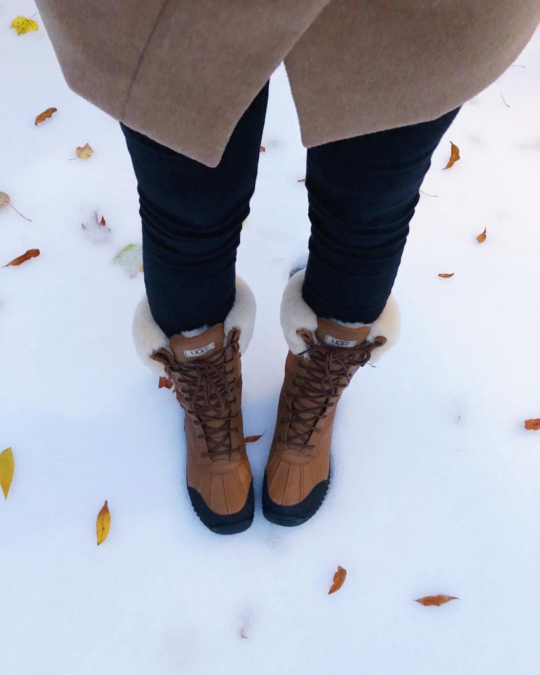 High UGG Boots: 6 Tall Styles From Classic to Adirondack 6 Tan lace-up waterproof boots with faux-fur lining standing in white snow with leaves.