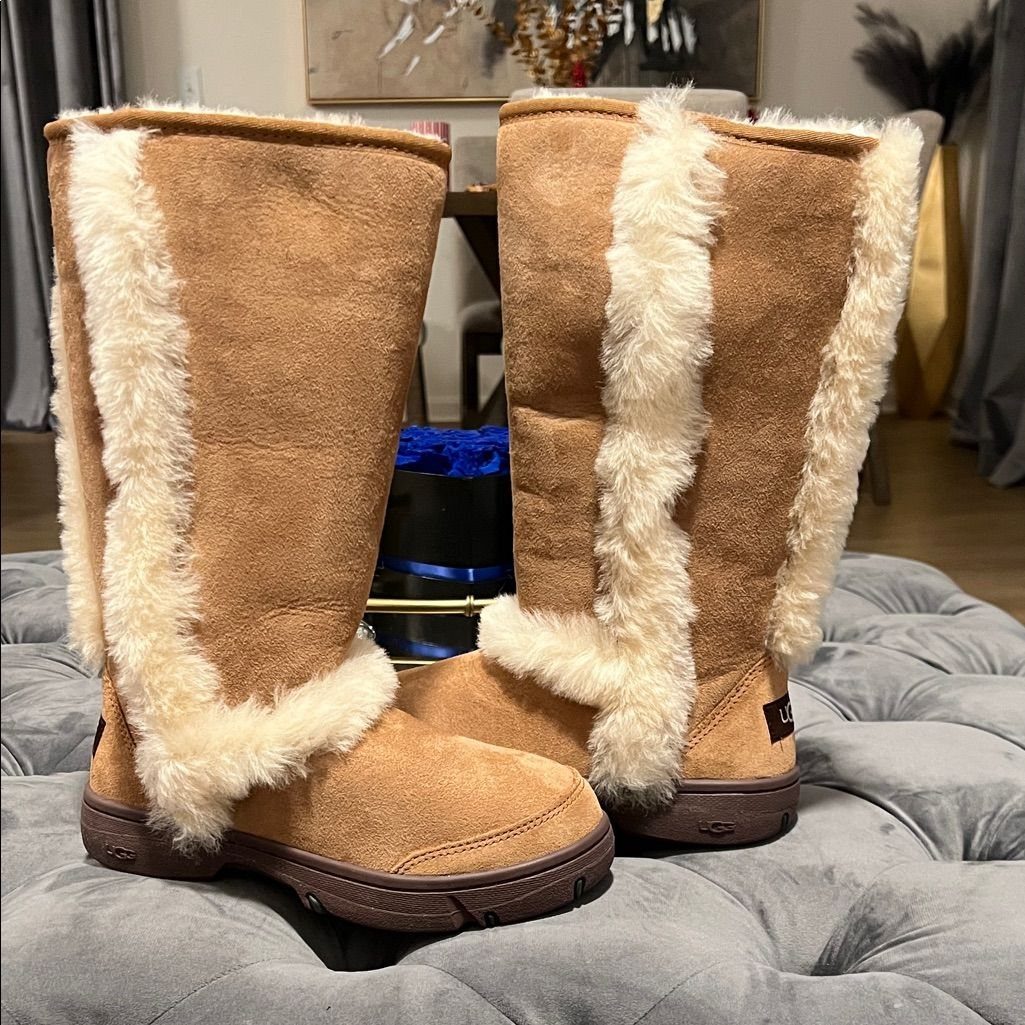 High UGG Boots: 6 Tall Styles From Classic to Adirondack 5 Tan suede tall boots with cream faux-fur trim on a grey velvet ottoman