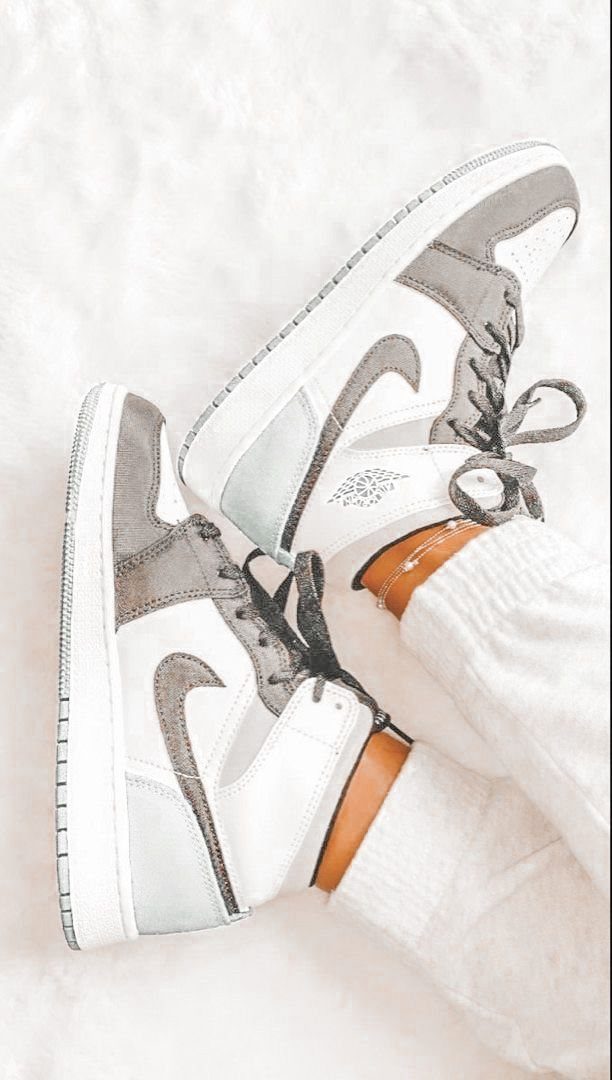 White and grey high-top sneakers worn with white socks on a white background