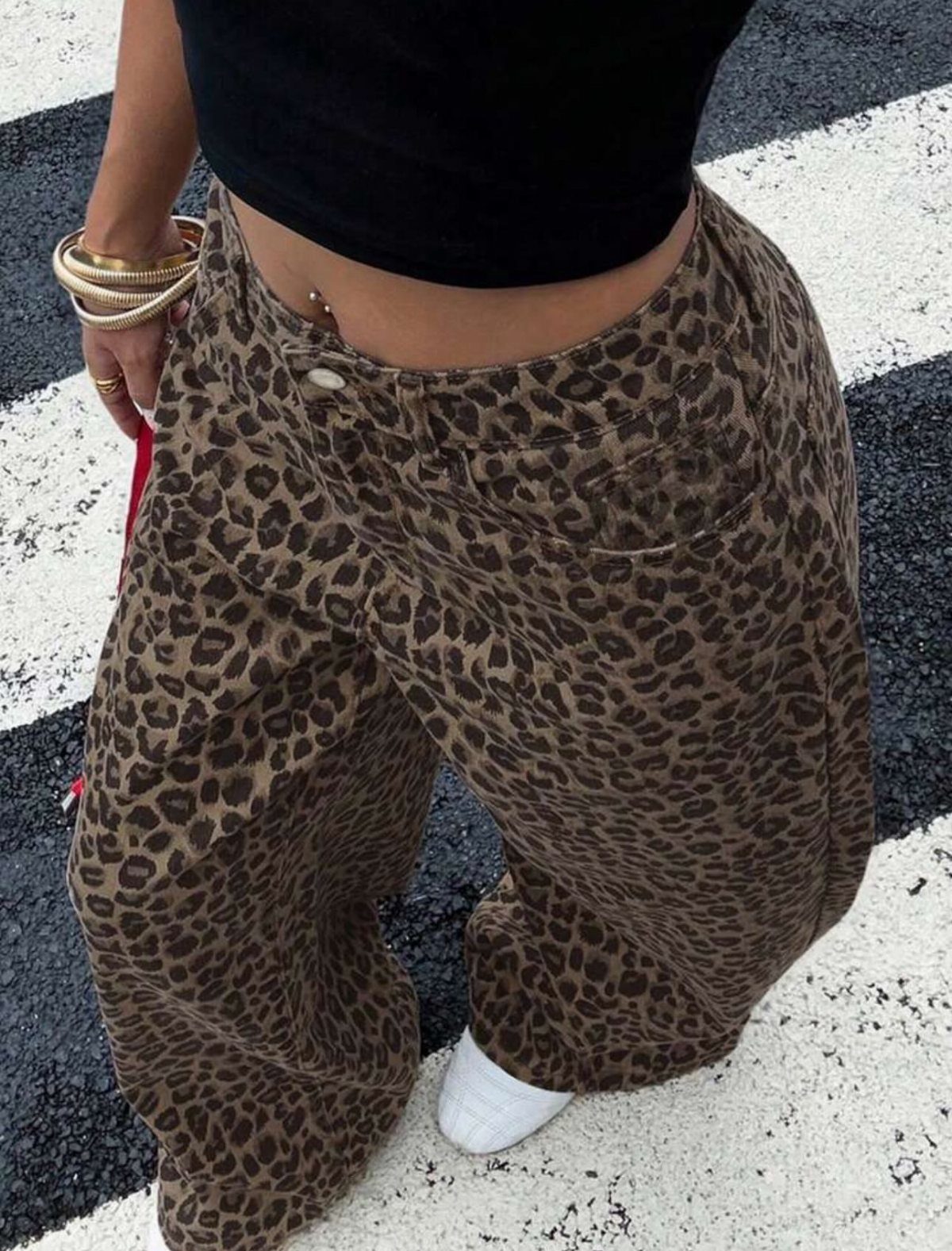 Leopard print wide-leg trousers paired with a black crop top and white sneakers.