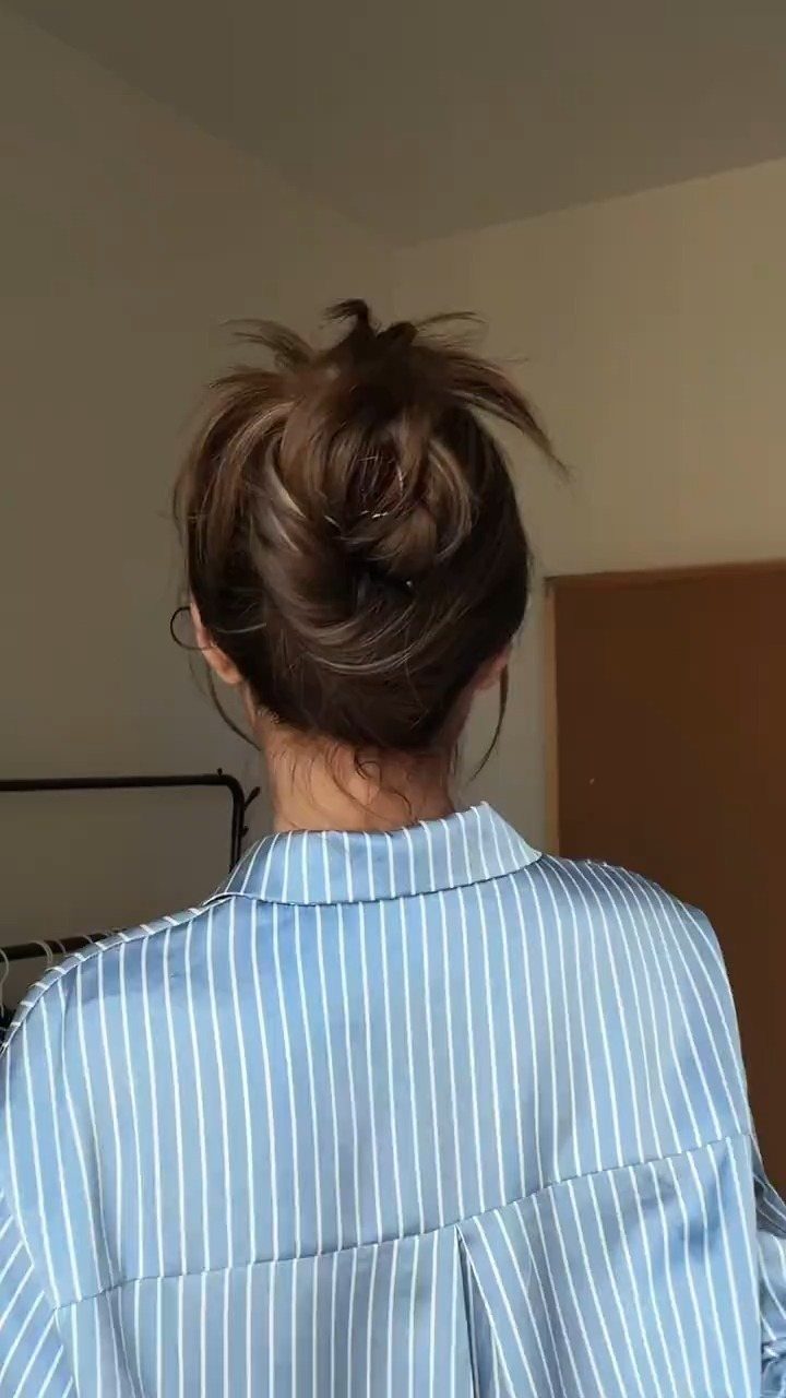 9 Long Hair Tutorial Ideas: Braids, Buns and Ponytails 3 Brown hair styled in a messy bun, viewed from behind wearing a striped shirt.