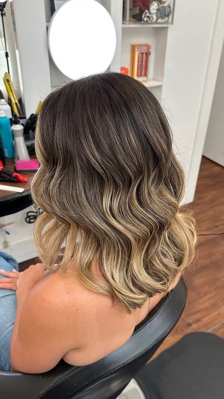 9 Medium Length Perm Hair Ideas with Waves and Curls 4 Medium-length blonde and brown hair styled in loose, beachy waves from behind.