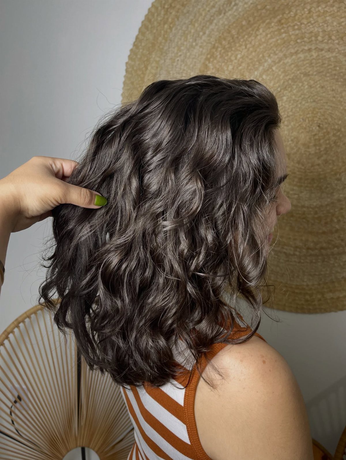 9 Medium Length Perm Hair Ideas with Waves and Curls 1 Woman with a dark brown bob haircut featuring soft, voluminous wavy curls.