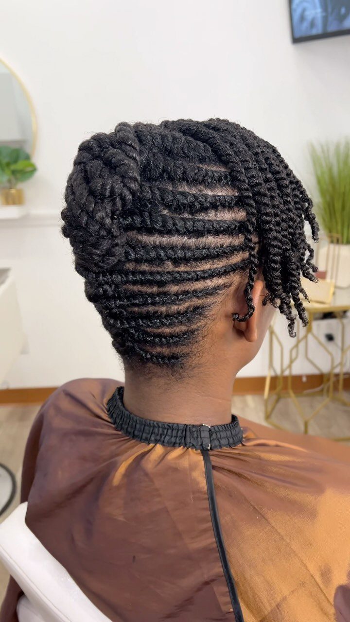 Black hair styled in horizontal twists gathered into a textured back bun.
