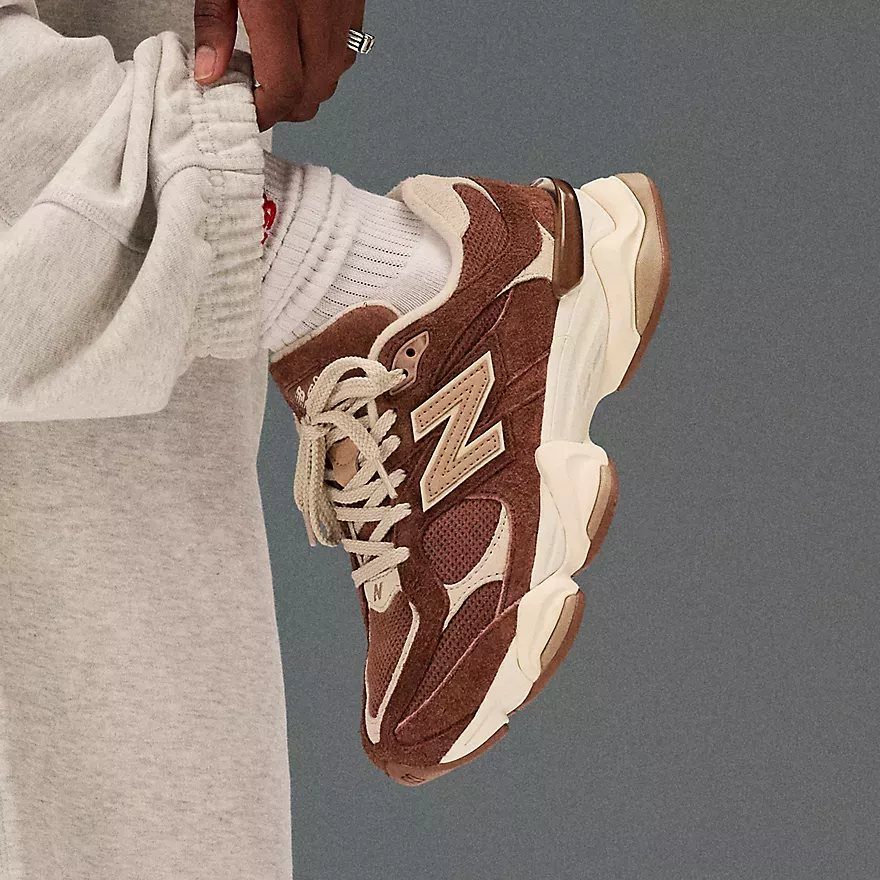 Brown New Balance 9060 truffle sneakers worn with grey sweatpants and white socks.