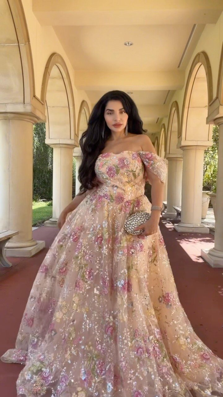 10 Nice Prom Dresses for Every Style and Body Type 1 Woman in a floral sequined A-line prom gown standing in a colonnade