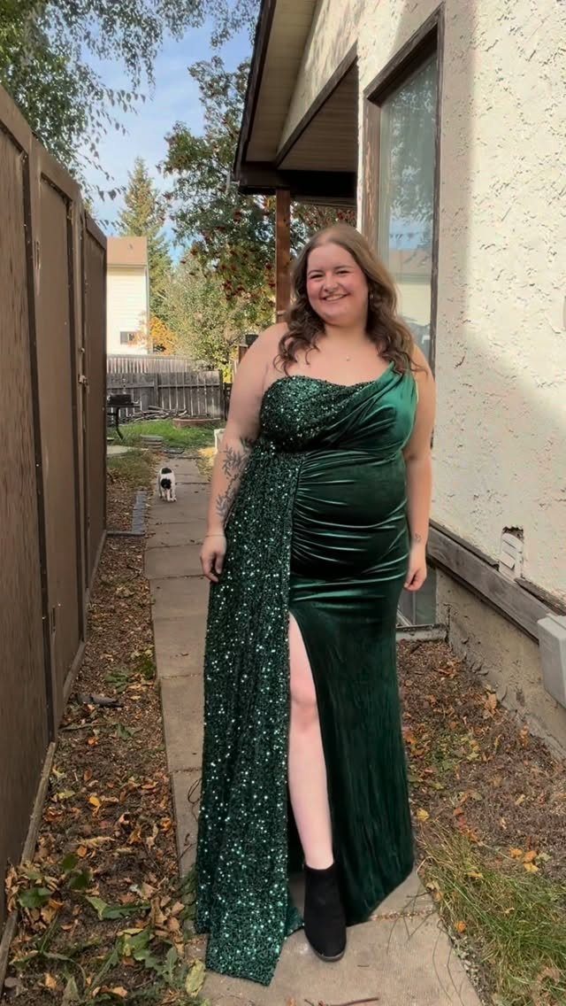 10 Nice Prom Dresses for Every Style and Body Type 5 Woman wearing a long dark green velvet prom dress with a sparkly overlay.