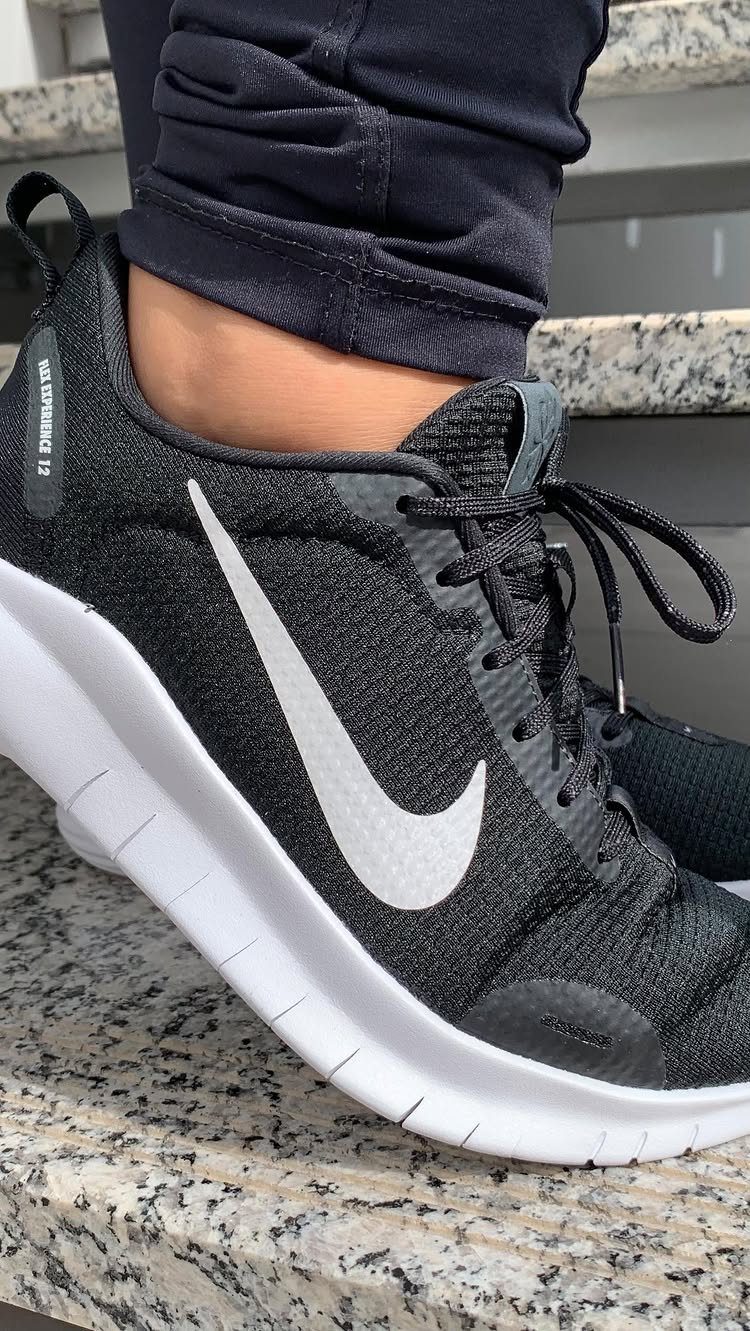 Nike Free Shoes: 7 Colorways and Styles to Wear Right Now 3 Black Nike sneaker with white swoosh and sole on a granite surface.