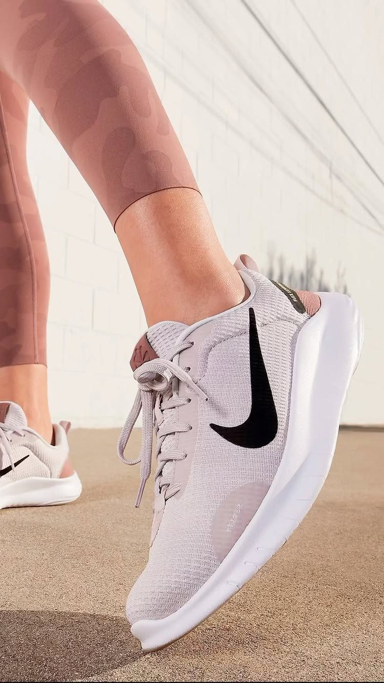Nike Free Shoes: 7 Colorways and Styles to Wear Right Now 2 Light purple Nike Free Run sneakers with black swoosh on a person's feet.