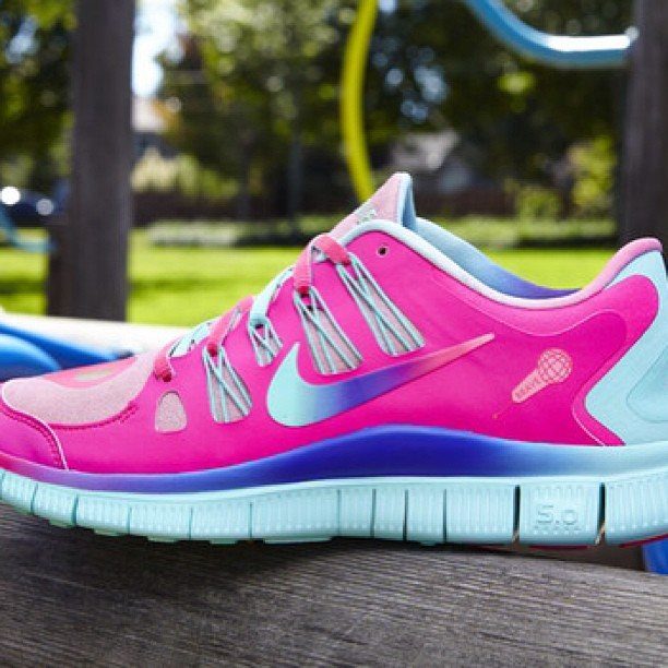 Nike Free Shoes: 7 Colorways and Styles to Wear Right Now 7 Pink and light blue Nike Free sneaker resting on a wooden surface outdoors.
