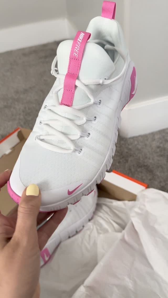 Nike Free Shoes: 7 Colorways and Styles to Wear Right Now 5 White Nike Free sneakers with pink accents held by a hand over a box.