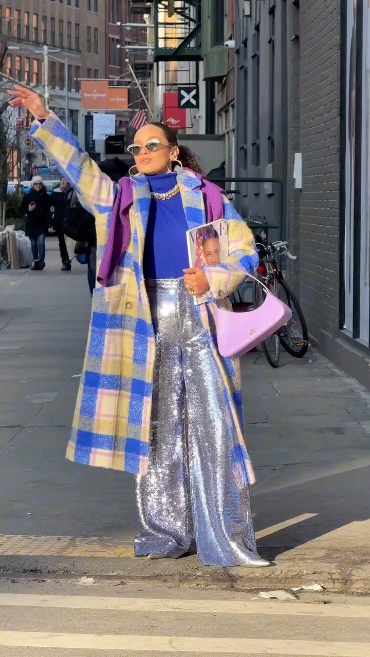 Woman in silver sequined pants and plaid coat walking on a city street