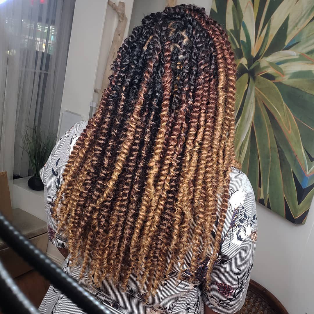 Long passion twists transitioning from black roots to golden blonde ombre ends.