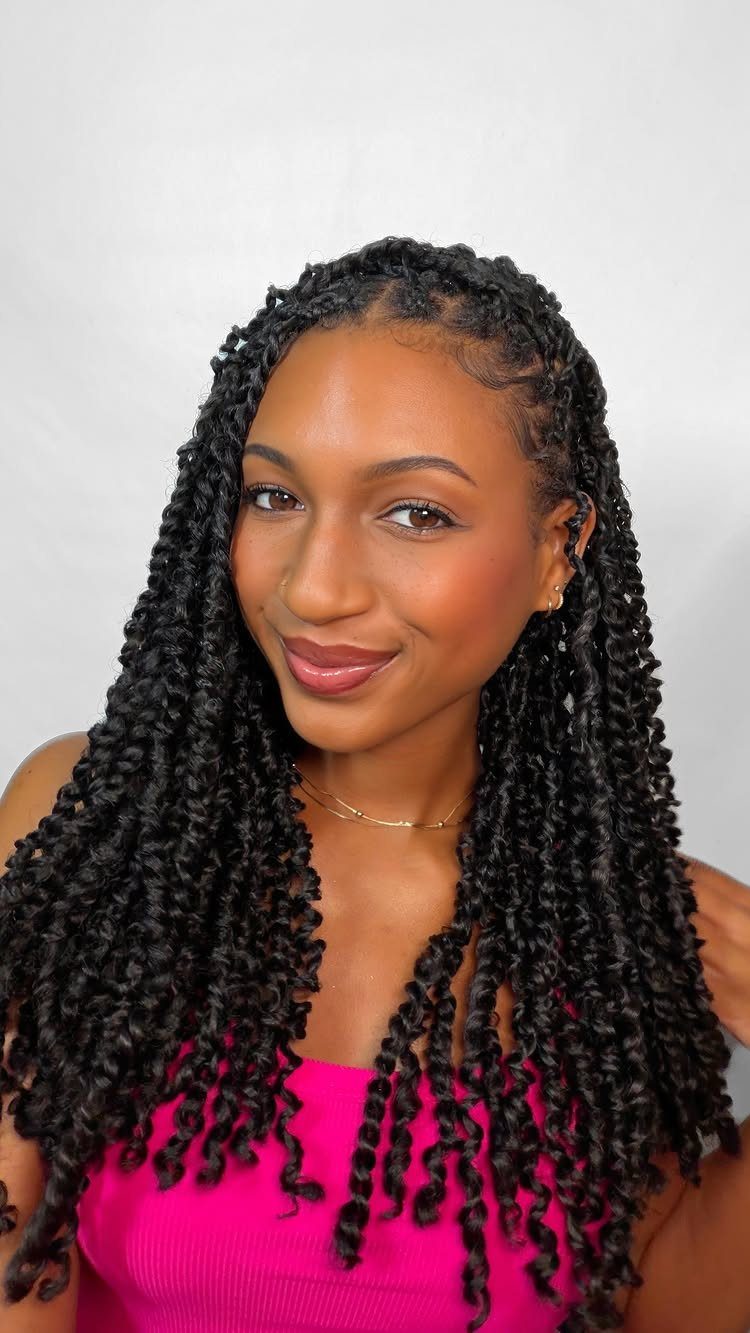 Woman with long black passion twists and curly ends wearing a pink top