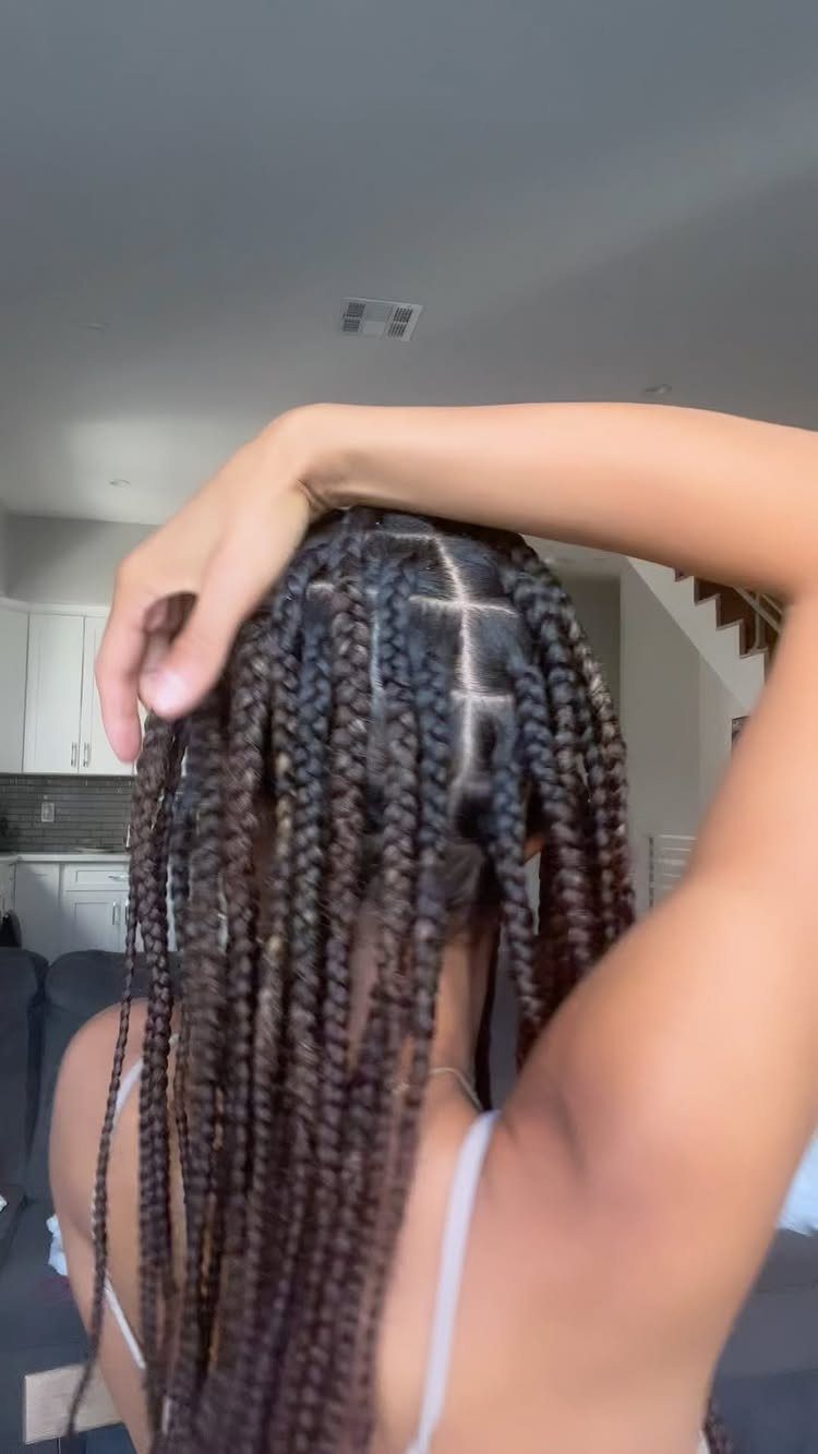 Long dark brown knotless braids with neat square parts on the scalp.