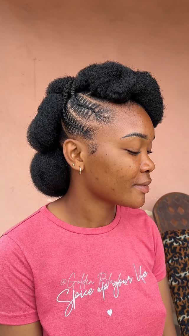 Woman with a protective updo featuring cornrows and voluminous hair puffs.