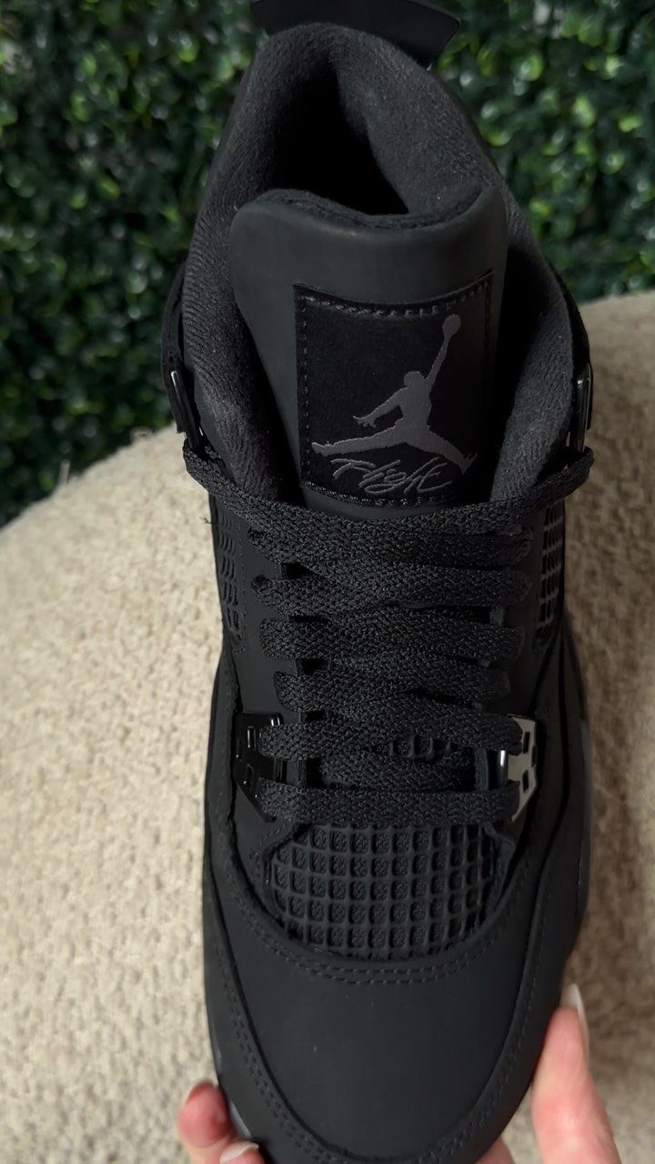 All-black Air Jordan 4 sneaker shown from the front against a neutral background.