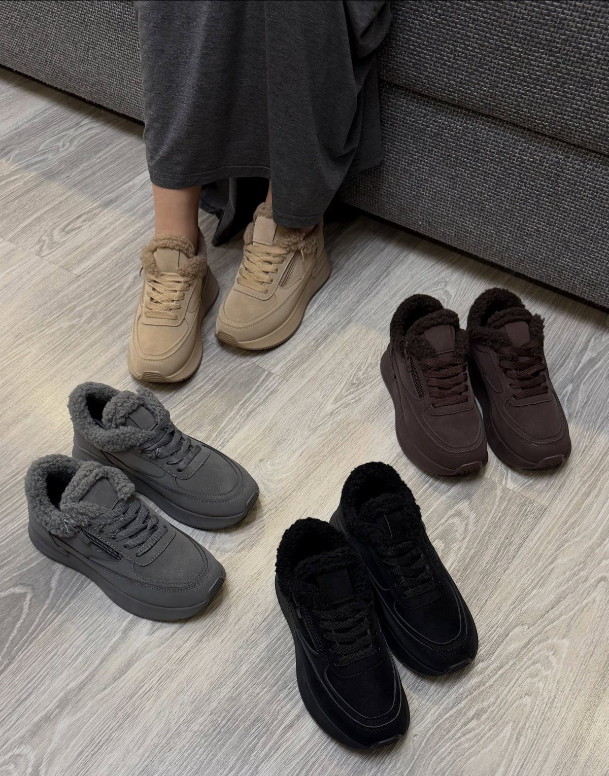 Fur-lined sneakers in beige, grey, brown, and black on a light wood floor.
