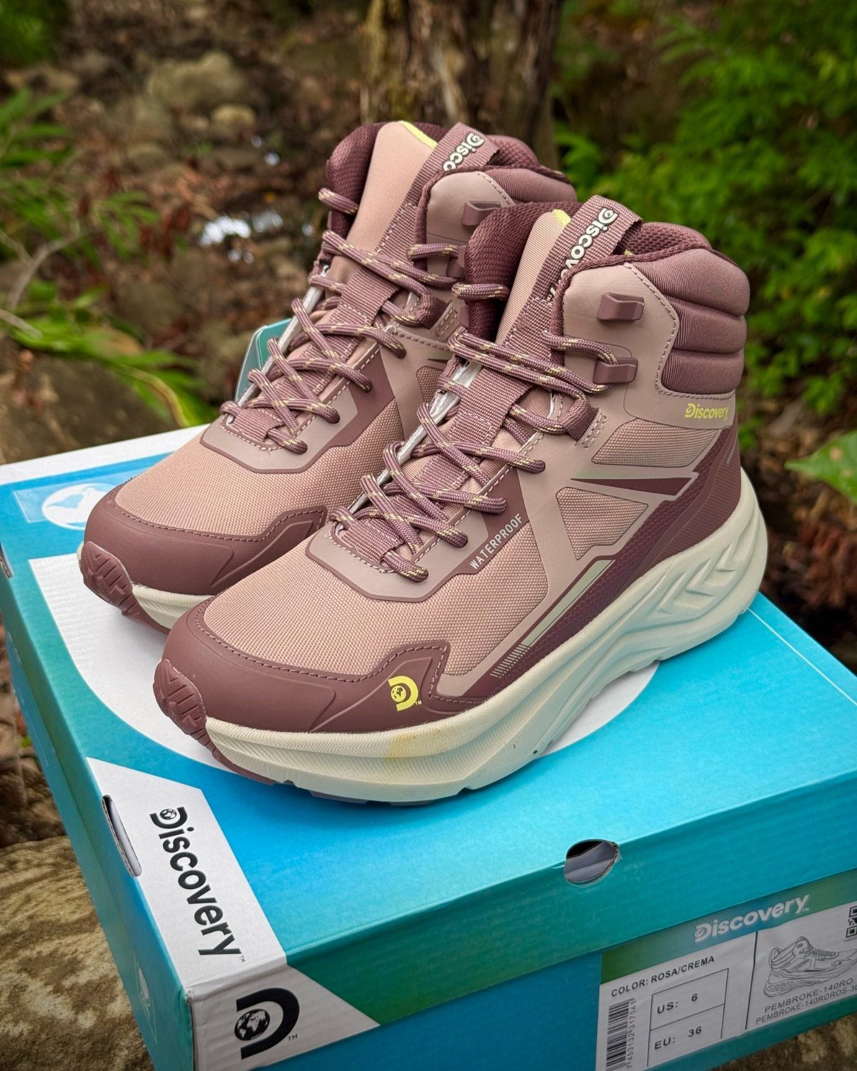 Mauve water-resistant casual boots with cream soles sitting on a blue shoe box.