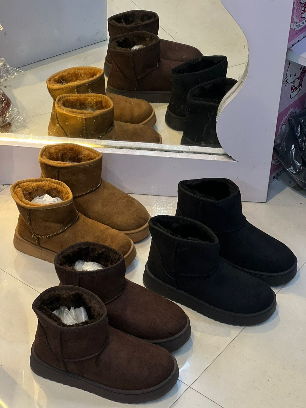 Short UGG Boots: 7 Outfit Ideas for Jeans, Skirts and Blazers 2 Short sheepskin boots in black, chestnut, and sand colors on a white floor.