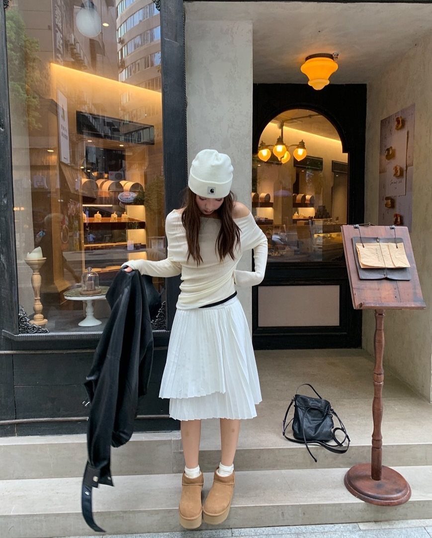 Short UGG Boots: 7 Outfit Ideas for Jeans, Skirts and Blazers 5 Woman wearing tan short sheepskin boots and white outfit standing outside a shop
