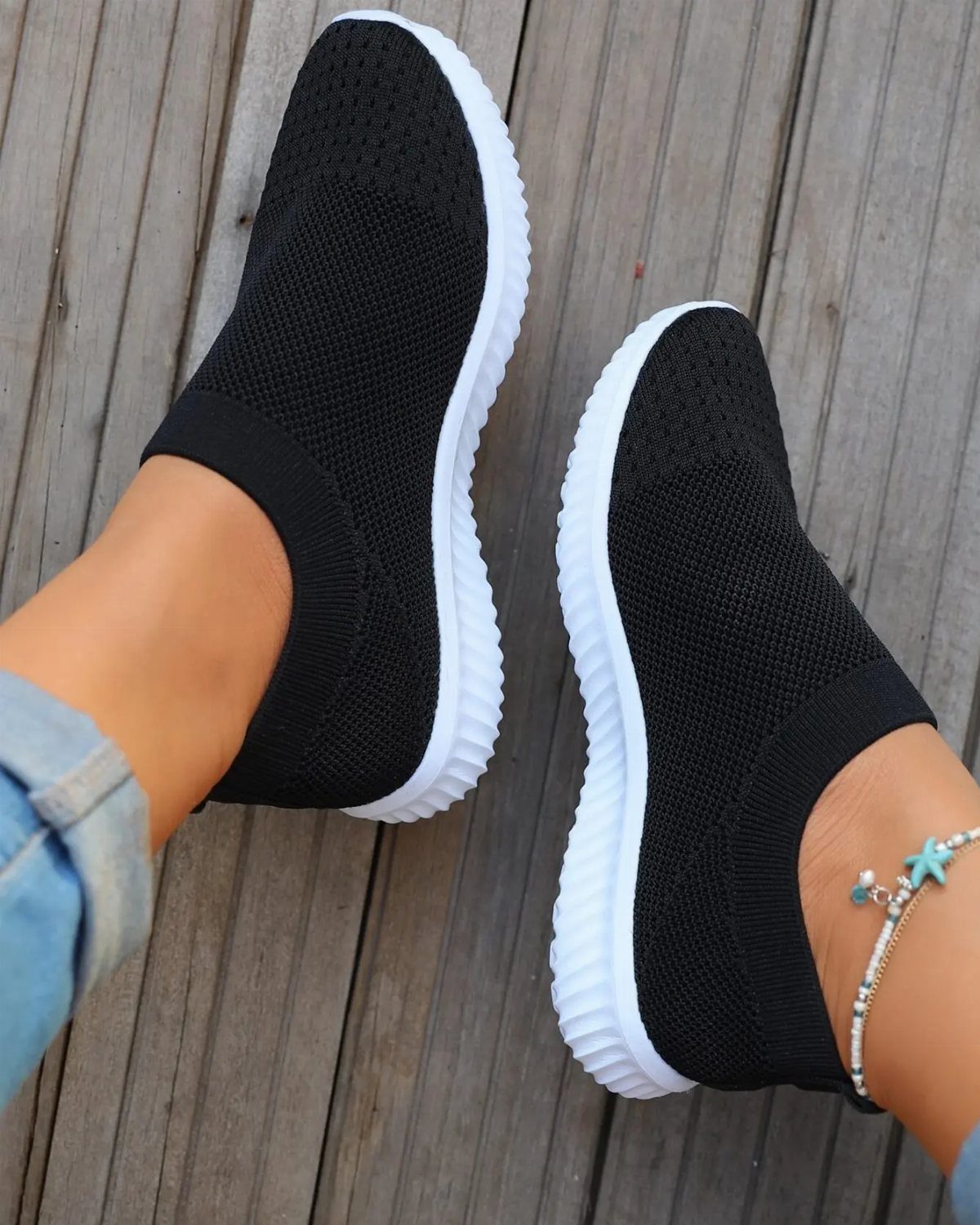 Sneakers to Wear With Shorts: 5 Ideas for Easy Summer Outfits 1 Black knit slip-on sneakers with white soles worn with light blue denim shorts.