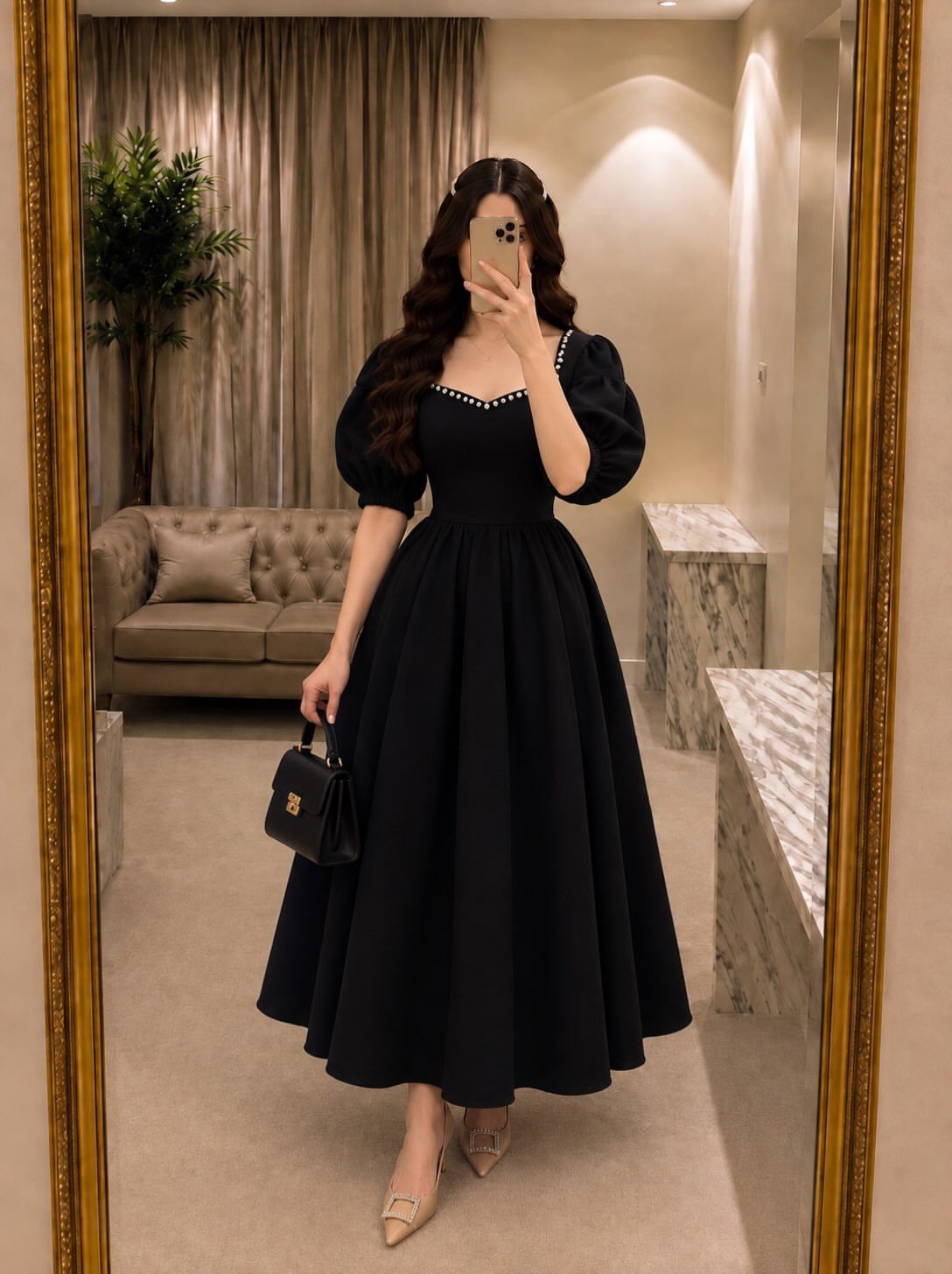 Woman in a voluminous black maxi dress with puff sleeves and nude heels.