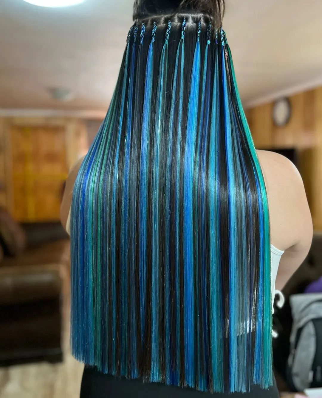 Long dark hair with thin turquoise blue extensions attached by small beads