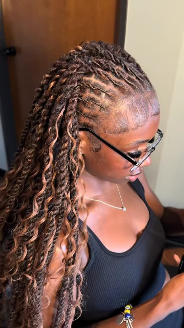 Woman with long brown and blonde asymmetrical two strand twists and glasses.