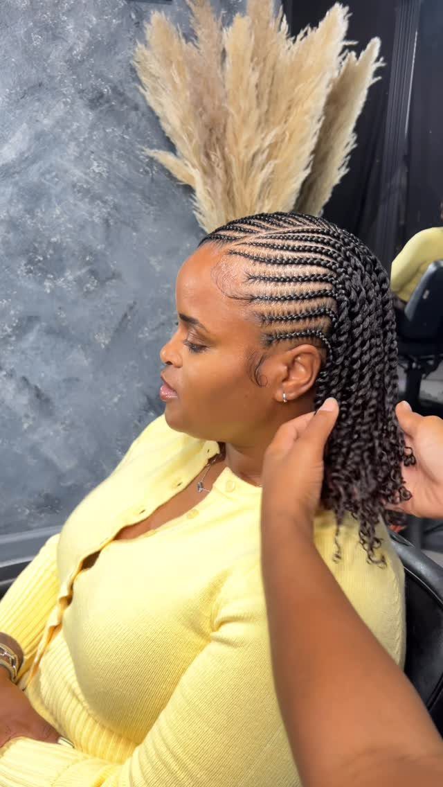 Woman with cornrows and two strand twists wearing a yellow cardigan in a salon.