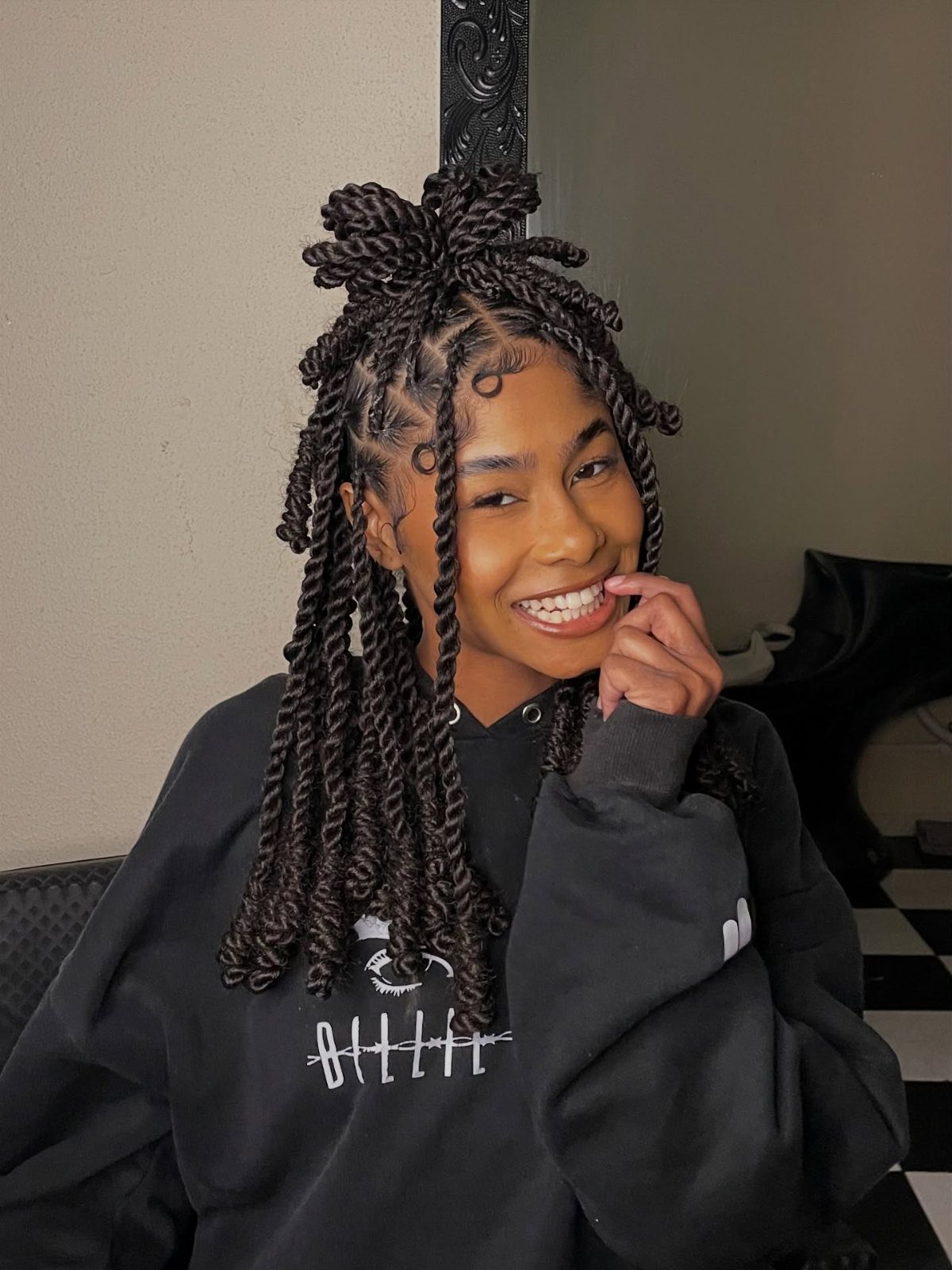 Woman with thick two strand twists styled in a half-up half-down look.