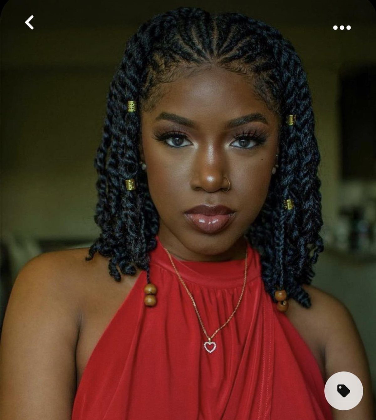 Woman with black two strand twist hair and gold cuffs wearing red top