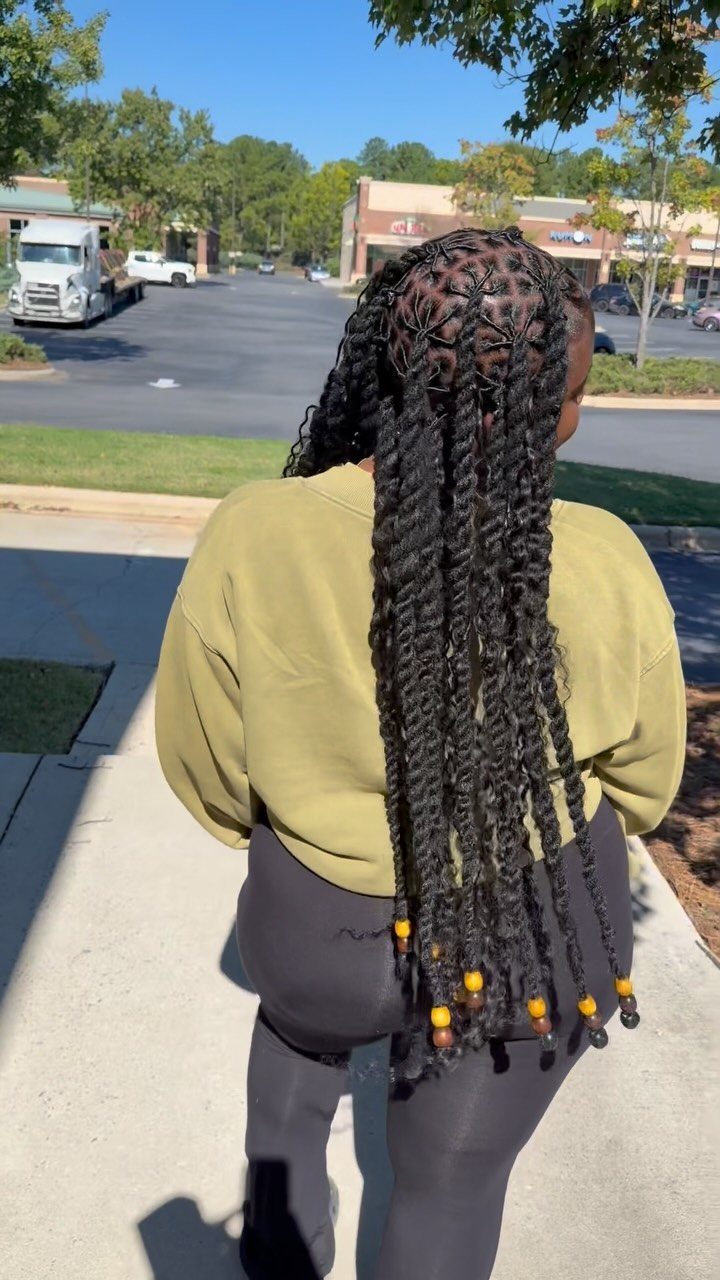 Long black two strand twists with yellow and brown beads at the ends.