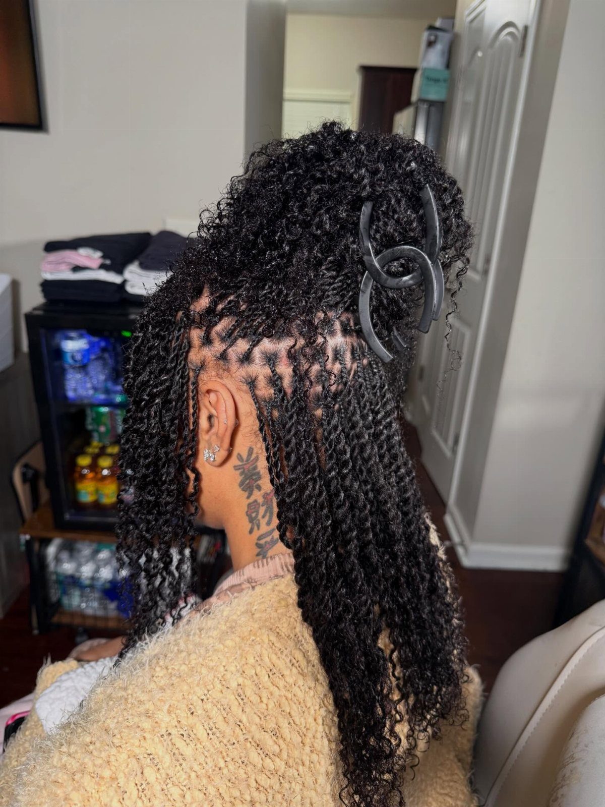 Long black two-strand twists gathered into a high ponytail with a claw clip.