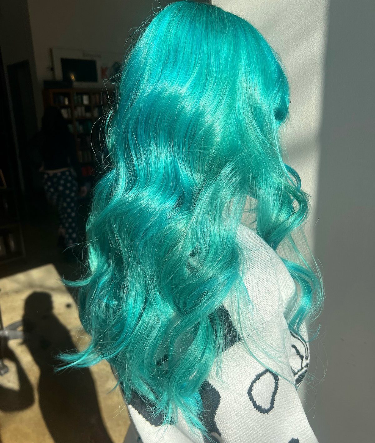 Types of Hair Colour: 12 Ideas, From Balayage to Copper 11 Long wavy turquoise blue hair on a person seen from behind indoors.