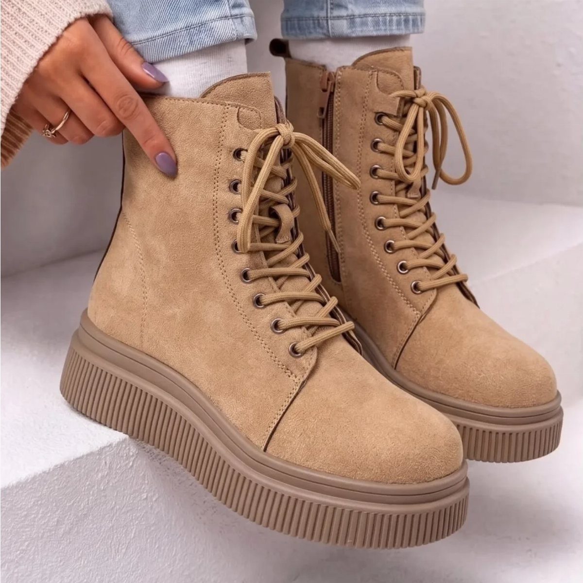 Winter Boots 2026: 8 Styles, From Slouchy to Shearling 4 Tan suede lace-up boots with thick ribbed lug soles worn with blue jeans.